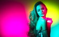 Fashion model brunette woman in colorful bright neon lights posing in studio. Beautiful girl, trendy art design make Royalty Free Stock Photo