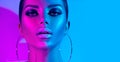 Fashion model brunette woman in colorful bright neon lights posing in studio. Beautiful girl, trendy glowing makeup