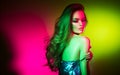 Fashion model brunette woman in colorful bright neon lights posing in studio. Beautiful girl, trendy makeup Royalty Free Stock Photo