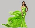 Fashion Model dancing in Green Silk Dress with Flying Chiffon Fabric. Beauty Woman in Long Satin Evening Gown over White. Elegant Royalty Free Stock Photo