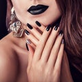 Fashion model with dark make-up, long hair and black and silver trendy manicure wearing jewellery. Black lipstick Royalty Free Stock Photo