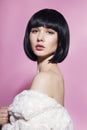 Fashion model girl face, beauty woman make up. Bob black hairstyle. Brunette woman posing over pink background. Royalty Free Stock Photo