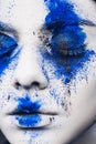 Fashion model girl portrait with colorful powder make up. woman with bright blue makeup and white skin. Abstract fantasy