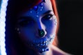 Fashion model with halloween skull makeup with glitter and rhinestones with creative color lightning Royalty Free Stock Photo