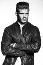 Fashion model in leather jacket standing with hands crossed