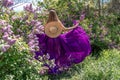 Fashion Model in Lilac Flowers, Young Woman in Beautiful Long Dress Waving on Wind, Outdoor Beauty Portrait in Blooming Royalty Free Stock Photo