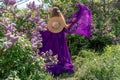 Fashion Model in Lilac Flowers, Young Woman in Beautiful Long Dress Waving on Wind, Outdoor Beauty Portrait in Blooming Royalty Free Stock Photo