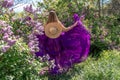 Fashion Model in Lilac Flowers, Young Woman in Beautiful Long Dress Waving on Wind, Outdoor Beauty Portrait in Blooming Royalty Free Stock Photo