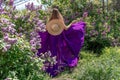 Fashion Model in Lilac Flowers, Young Woman in Beautiful Long Dress Waving on Wind, Outdoor Beauty Portrait in Blooming