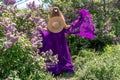 Fashion Model in Lilac Flowers, Young Woman in Beautiful Long Dress Waving on Wind, Outdoor Beauty Portrait in Blooming Royalty Free Stock Photo