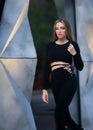 Fashion model with long blonde hair walks outdoors. High fashion portrait of young elegant woman. Royalty Free Stock Photo