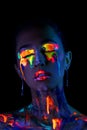 Fashion model in neon light with fluorescent paint. Body Art design in UV over dark background Royalty Free Stock Photo