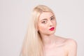 Fashion model posing at studio. Beautiful woman with long straight blond hair, red lips and make-up Royalty Free Stock Photo