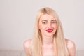 Fashion model posing at studio. Smiling beautiful woman with long straight blond hair, white teeth, red lips and make-up Royalty Free Stock Photo