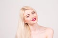 Fashion model posing at studio. Smiling beautiful woman with long straight blond hair, white teeth, red lips and make-up Royalty Free Stock Photo