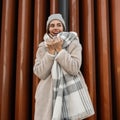Fashion model of a pretty happy young woman with a cute smile in fashionable faux fur coat in a knitted stylish hat with a woolen Royalty Free Stock Photo