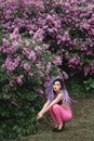 Fashion model sitting under the lilac tree Royalty Free Stock Photo