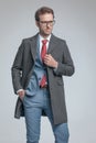Fashion model sticking a hand in pocket, fixing his coat Royalty Free Stock Photo