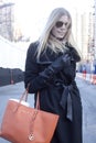 Fashion model Street Style wearing aviator sunglasses and orange handbag during Fashion Week