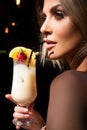 Fashion model in stylish summer outfit enjoying cocktail party, holding tasty alcohol cocktail. Sexy woman drinking Royalty Free Stock Photo