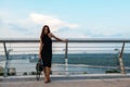 Fashion model wearing black elegant dress posing outdoor at the bank of Dniper river in Kyiv, Ukraine. Young beautiful brunette Royalty Free Stock Photo