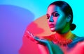 Fashion model woman in colorful bright lights with trendy makeup and manicure posing Royalty Free Stock Photo
