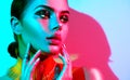 Fashion model woman in colorful bright lights with trendy makeup and manicure Royalty Free Stock Photo