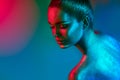 Fashion model woman in colorful bright sparkles and neon lights posing in studio, portrait of beautiful girl Royalty Free Stock Photo