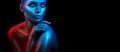 Fashion model woman in colorful bright sparkles and neon lights posing in studio, portrait of beautiful girl Royalty Free Stock Photo