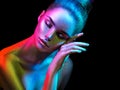 Fashion model woman in colorful bright sparkles and neon lights posing in studio, portrait of beautiful girl Royalty Free Stock Photo