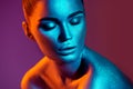 Fashion model woman in colorful bright sparkles and neon lights posing in studio, portrait of beautiful girl Royalty Free Stock Photo