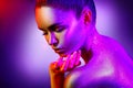 Fashion model woman in colorful bright sparkles and neon lights posing in studio, portrait of beautiful girl Royalty Free Stock Photo