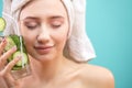 Spa woman with towel on head holding glass of cucumber water isoalted over blue Royalty Free Stock Photo