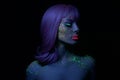 Fashion model woman in neon light bright fluorescent makeup, long hair, drop on face. Beautiful model pink hair girl colorful make Royalty Free Stock Photo