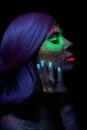 Fashion model woman in neon light bright fluorescent makeup, long hair, drop on face. Beautiful model pink hair girl colorful make Royalty Free Stock Photo