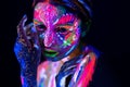 Fashion model woman in neon light, portrait of beautiful model girl with fluorescent make-up, Body Art design of female Royalty Free Stock Photo