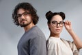 Fashion models couple wearing glasses. Sexy woman and handsome young man portrait over lite background. Attractive Royalty Free Stock Photo