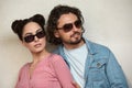 Fashion models couple wearing sunglasses. Sexy woman and handsome young man portrait over lite background. Attractive Royalty Free Stock Photo