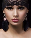 Fashion muslim portrait. Beautiful gypsy young woman with professional makeup and lace accessories over black