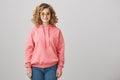 Fashion is in my blood. Good-looking caucasian girl with curly hair wearing trendy eyewear and pink hoodie, smiling and Royalty Free Stock Photo