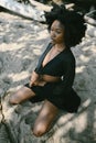 Fashion outdoor beach portrait Beautiful young African American Black woman posing outside on sandy coast with big green Royalty Free Stock Photo