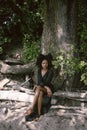 Fashion outdoor beach portrait Beautiful young African American Black woman posing outside on sandy coast with big green Royalty Free Stock Photo