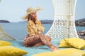 Fashion outdoor photo of beautiful girl posing on the wicker nest chair Royalty Free Stock Photo