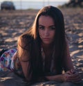 Fashion outdoor photo of beautiful sexy woman with dark hair in light shirt relaxing at the beach Royalty Free Stock Photo