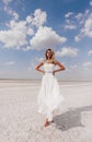 Beautiful woman with blond hair in elegant wedding dress posing in salt lake Royalty Free Stock Photo