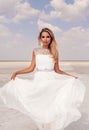 Beautiful woman with blond hair in elegant wedding dress posing in salt lake Royalty Free Stock Photo