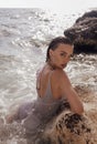 Beautiful woman with dark hair in elegant beach dress posing on sunset beach Royalty Free Stock Photo