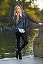 Fashion outdoor photo of beautiful woman wearing coat and leggings posing against the Royalty Free Stock Photo