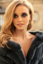 Woman with blond hair and evening maleup in elegant fur coat Royalty Free Stock Photo