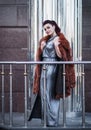 Fashion outdoor photo of glamour woman with dark hair wearing luxurious fur coat and leather gloves Royalty Free Stock Photo